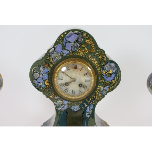 80 - A Rozenberg Art Nouveau earthenware three piece clock garniture, decorated with lilac pansies on a g... 