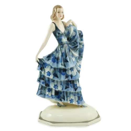 85 - A Goldscheider Art Deco pottery figure of a dancer, modelled by Dakon, wearing a blue floral dress, ... 