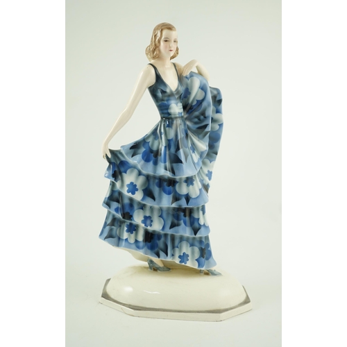 85 - A Goldscheider Art Deco pottery figure of a dancer, modelled by Dakon, wearing a blue floral dress, ... 