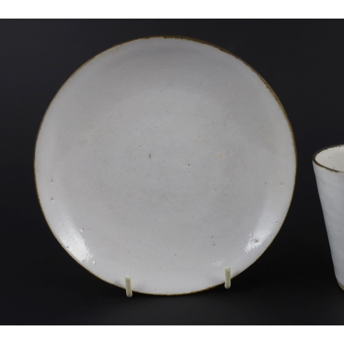 86 - Dame Lucie Rie (1902-1995) a cup, saucer and side plate, c.1959, each white glazed stoneware with ma... 