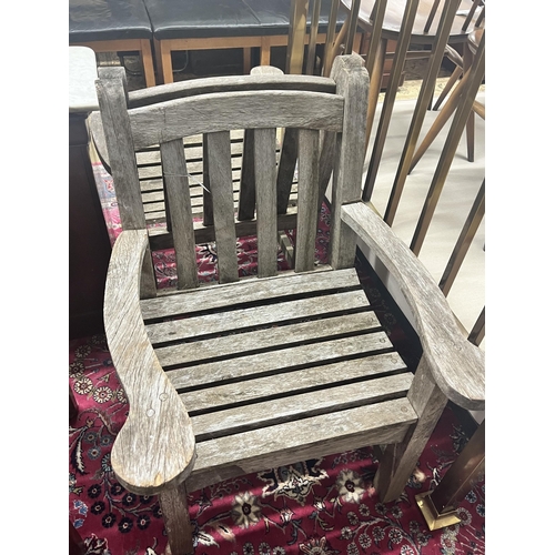 53 - A pair of weathered teak slatted garden elbow chairs, width 64cm depth 60cm height 86cm