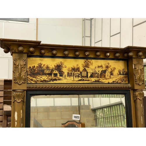 1023 - A Regency giltwood pier glass, with a verre eglomise frieze, width 69cm, height 103cm