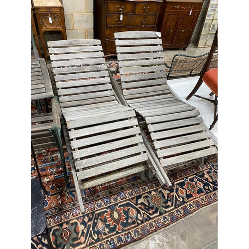 1081 - A pair of weathered teak garden loungers