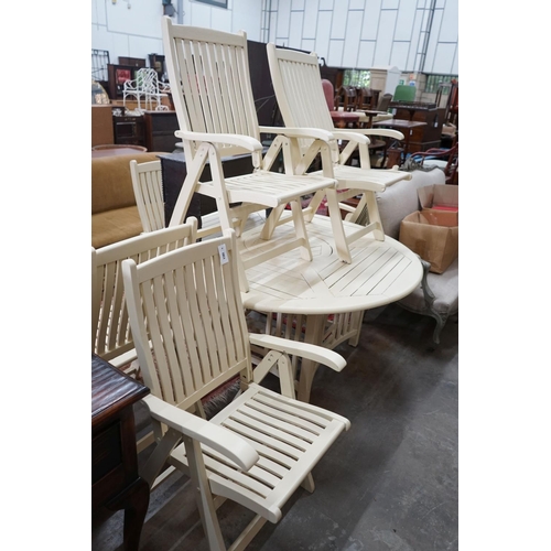 1084 - A circular painted teak garden table, diameter 150cm, height 72cm and six folding elbow chairs... 