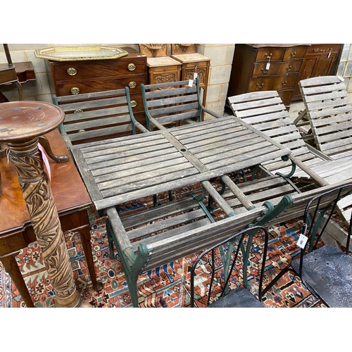 1117 - A rectangular slatted wood and cast metal garden table, length 137cm, depth 67cm, height 64cm togeth... 