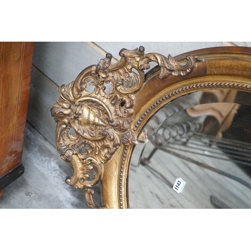 1133 - A 19th century French oval giltwood and gesso wall mirror with pierced 'C' scroll and shell pediment... 