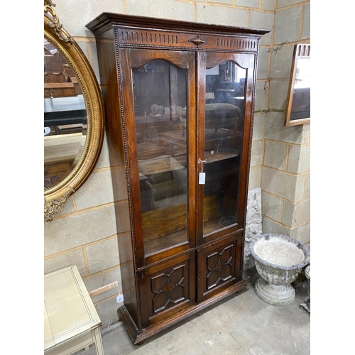 1134 - A 1920's glazed oak two door bookcase, width 100cm, depth 32cm, height 192cm