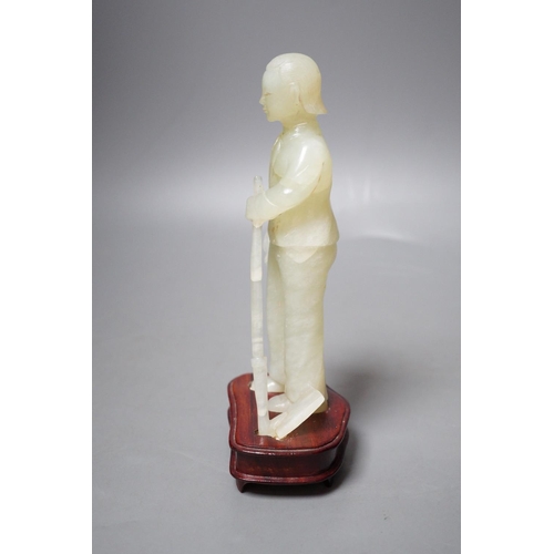 1253 - A Chinese carved bowenite jade figure of a worker on hardwood stand, 19cm