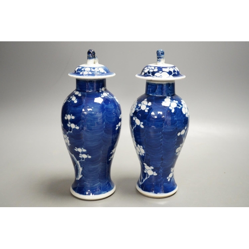 1329 - A pair of early 20th century Chinese blue and white prunus vases and covers, 21cm