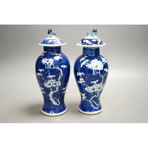 1329 - A pair of early 20th century Chinese blue and white prunus vases and covers, 21cm