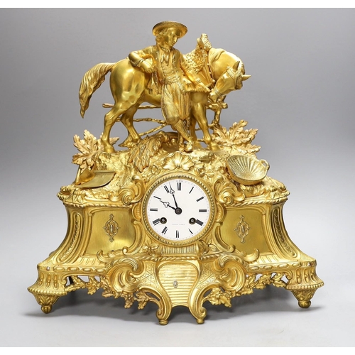 1388 - A 19th century French gilt brass mantel clock with man and horse, with key and pendulum, 38cm tall... 