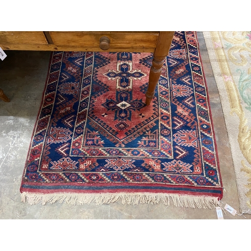 1156 - A Caucasian style red ground rug, 184 x 130cm