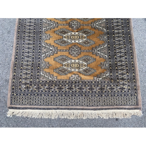 1157 - A Bokhara gold ground rug, 190 x 136cm