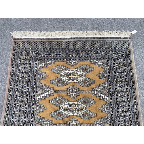 1157 - A Bokhara gold ground rug, 190 x 136cm