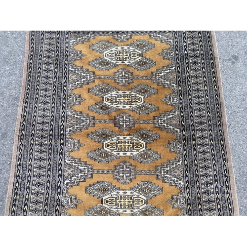 1157 - A Bokhara gold ground rug, 190 x 136cm