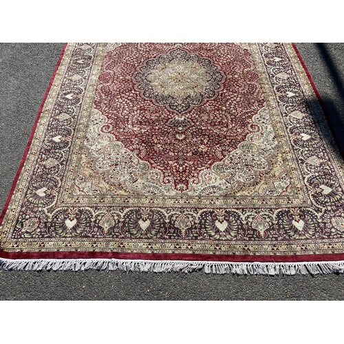 217 - A Kashmiri part silk burgundy ground floral carpet, 330 x 240cm