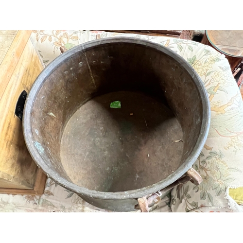 63 - A Victorian circular copper cauldron with wrought iron handles, diameter 56cm, height 42cm