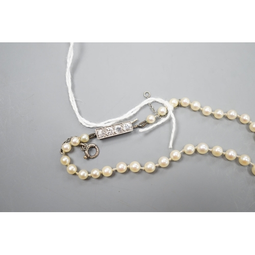 967 - A single strand graduated cultured pearl necklace, with four stone diamond set white metal clasp, 50... 