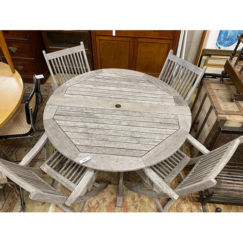 1049 - A circular weathered teak folding garden table, diameter 120cm, height 74cm, together with four teak... 