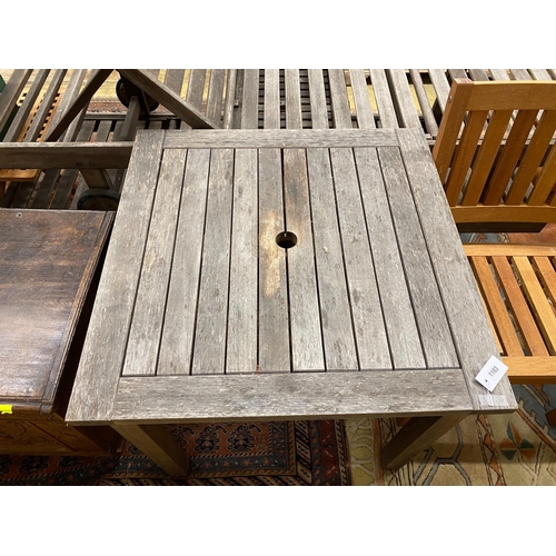 1103 - A weathered teak square garden table, width 80cm, height 73cm together with two teak elbow chairs... 