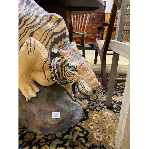 1113 - A painted stone garden ornament of a crouching tiger, tail detached, height 75cm