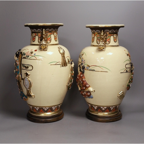 1299 - A pair of large Satsuma vases with relief decoration and dragon handles, 35cm tall with bases