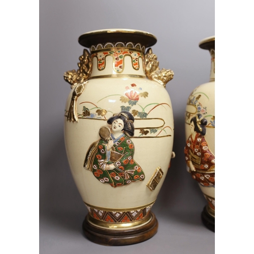 1299 - A pair of large Satsuma vases with relief decoration and dragon handles, 35cm tall with bases