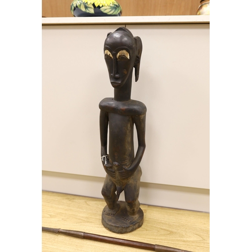 1352 - An African Baoule crouched tribal figure, together with a spear, 156cm long