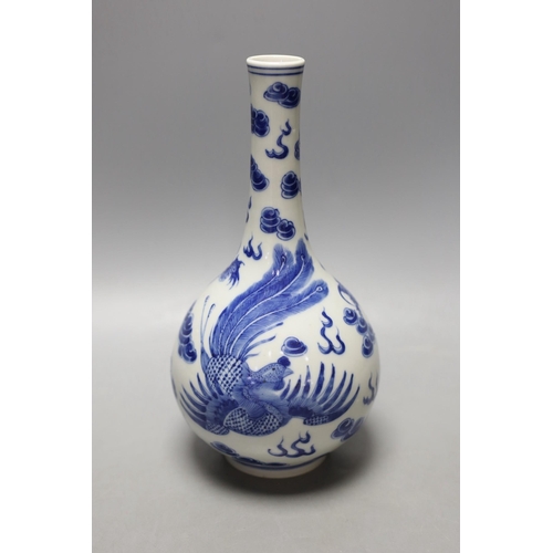 1467 - A Chinese  blue and white dragon and phoenix bottle vase, 23 cms high.