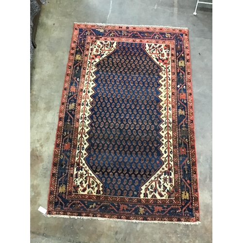 1079 - A North West Persian blue ground rug woven with rows of boteh, 196cm x 126cm