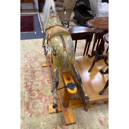 1184 - An early 20th century Ayers type dapple rocking horse with tan leather tack on pine safety frame, le... 