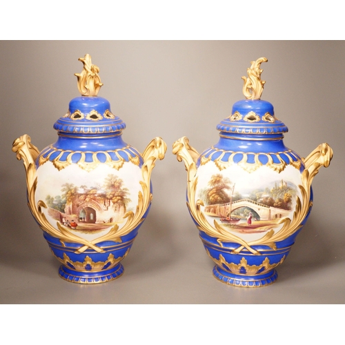 1356 - A pair of English bone China lidded two-handled vases, painted with river landscapes, within blue an... 