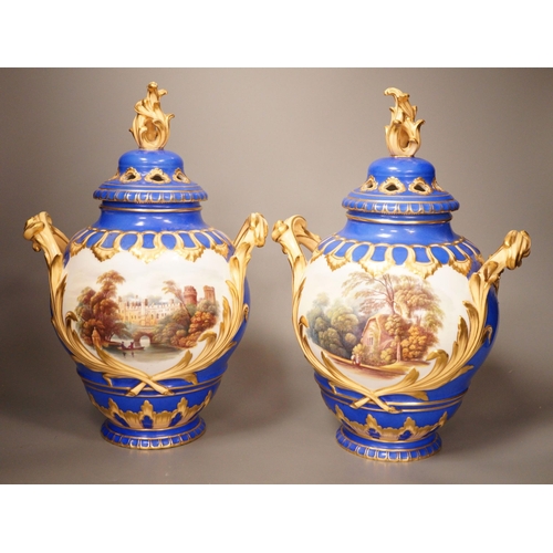 1356 - A pair of English bone China lidded two-handled vases, painted with river landscapes, within blue an... 