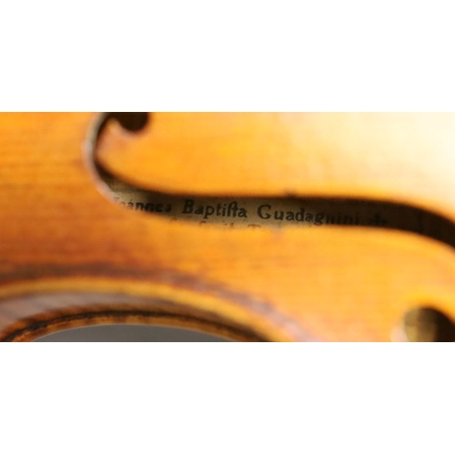 1283 - A 19th century violin labelled JB Guadagnini, back measures 35cm, with two bows, one silver-mounted.... 