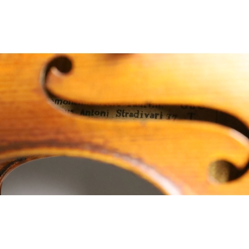 1283 - A 19th century violin labelled JB Guadagnini, back measures 35cm, with two bows, one silver-mounted.... 