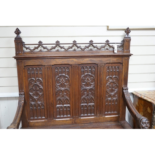 169 - An early 20th century Gothic style carved oak box seat settle, length 116cm, depth 45cm, height 154c... 