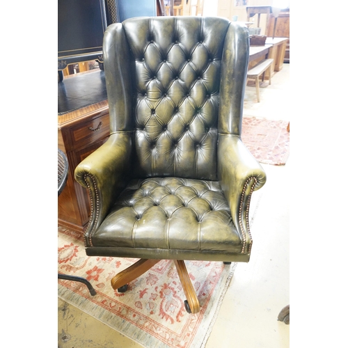 53 - A Victorian style buttoned green leather swivel desk wing armchair, width 78cm, height 120cm