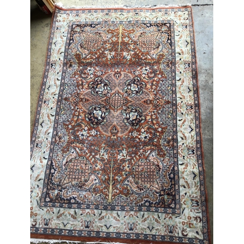 76 - A North West Persian style brick red ground rug, 190 x 126cm