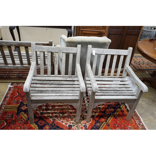 78 - A pair of slatted weathered teak garden elbow chairs, width 60cm, depth 58cm, height 83cm