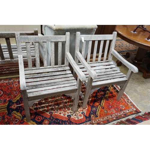 78 - A pair of slatted weathered teak garden elbow chairs, width 60cm, depth 58cm, height 83cm