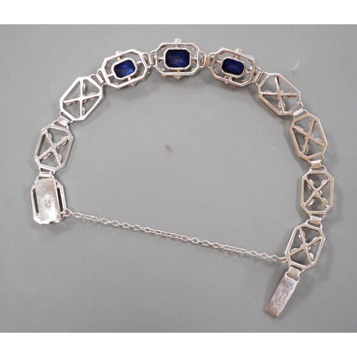 974 - A modern 9ct white metal and three stone emerald cut synthetic sapphire set pierced link bracelet, a... 