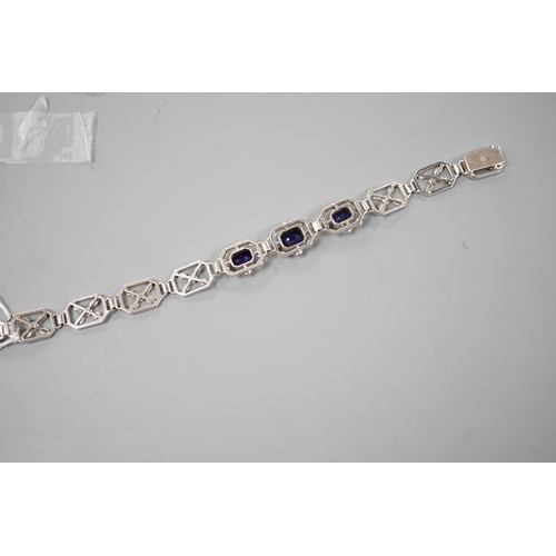 974 - A modern 9ct white metal and three stone emerald cut synthetic sapphire set pierced link bracelet, a... 