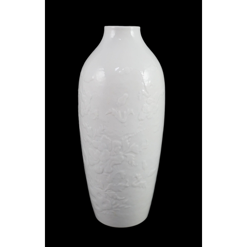 101 - A Chinese moulded white glazed vase, Qianlong period, relief moulded with peonies and rockwork, 18.3... 