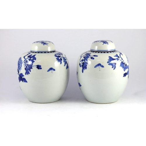 107 - A pair of Chinese blue and white jars and covers, 19th century, each painted with pheasants amid peo... 