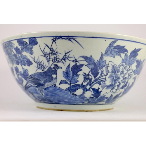 132 - A large Chinese blue and white bowl, 19th century, the interior painted with a bird amid flowers roc... 