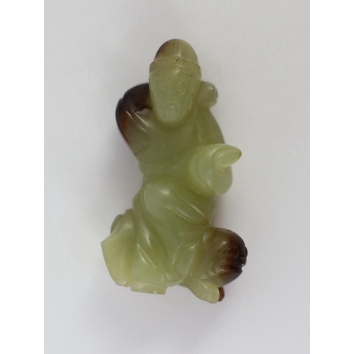 152 - A Chinese yellow and brown jade figure of a man seated on a creature, 19th century, the greenish yel... 