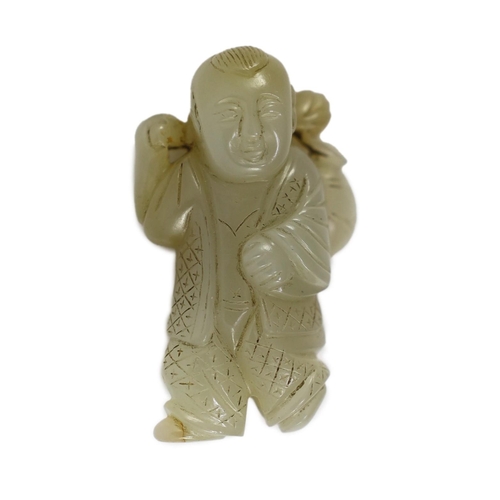 153 - A Chinese pale celadon jade figure of a boy, 19th century, standing and holding a lotus sprig in his... 