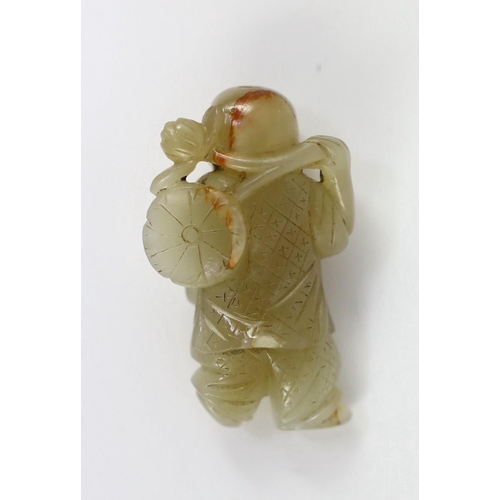 153 - A Chinese pale celadon jade figure of a boy, 19th century, standing and holding a lotus sprig in his... 