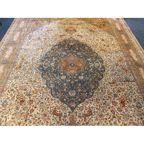 202 - An early 20th century Tabriz ivory ground carpet, with central lobed medallion and dense floral fiel... 