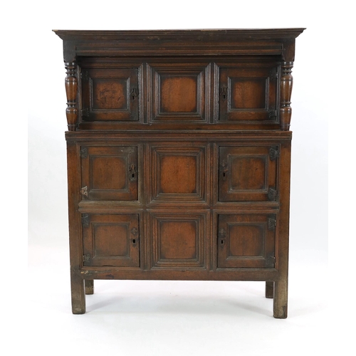 208 - A mid 18th century oak cupboard, with moulded cornice and three central dummy panels, each flanked b... 